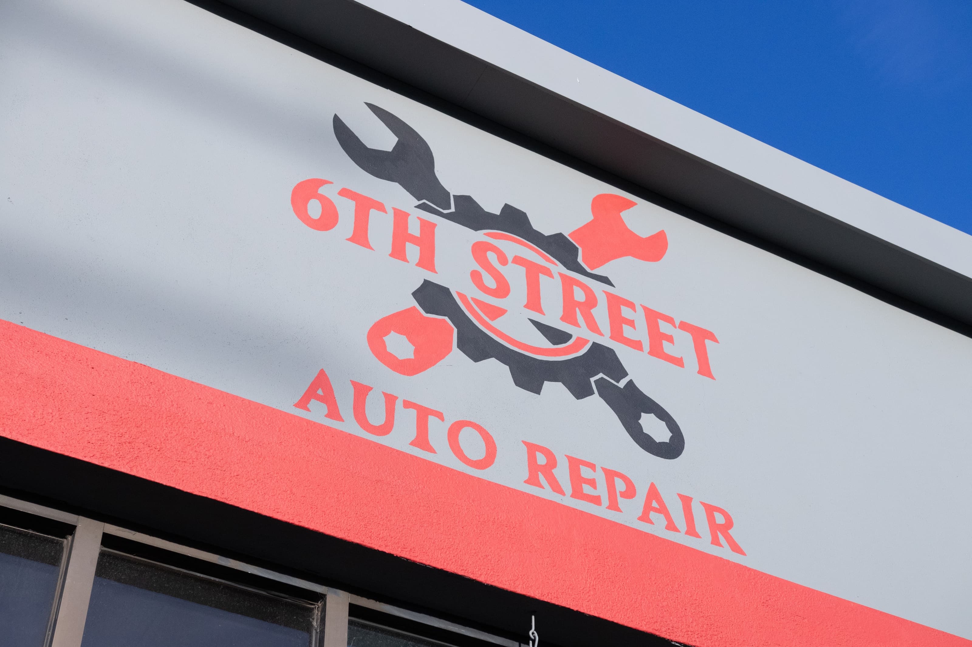 The 6th Street Auto Repair sign painted on the shop's exterior wall