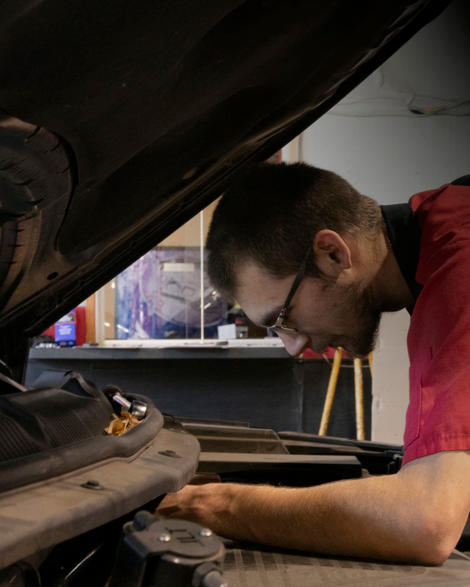 A 6th Street Auto Repair technician servicing a vehicle's brakes on the lift